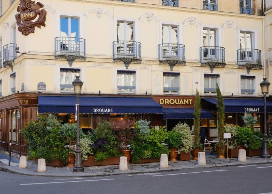 Front de rue de Drouant, place Gaillon, avec jardinières rectangulaires et bornes. Pas le gros plan de la petite terrasse de gauche.